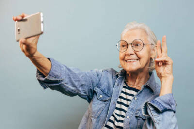 signora anziana smartphone selfie videochiamata