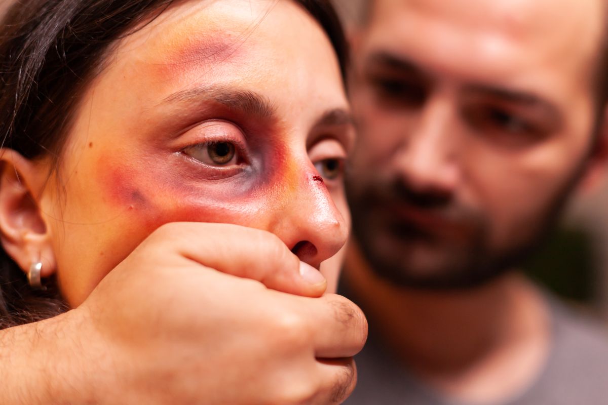 uomo tiene la bocca chiusa ad una donna che ha subito violenza, abuso, percosse