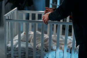 uomo vicino a un neonato in culla