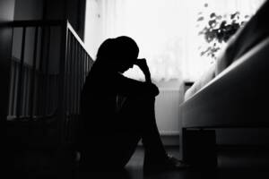donna depressa vicina alla culla di un neonato