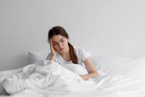 ragazza stanca seduta sul letto