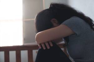 donna triste accanto ad una culla