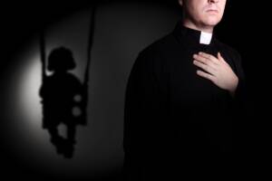 sacerdote con una bambina alle spalle