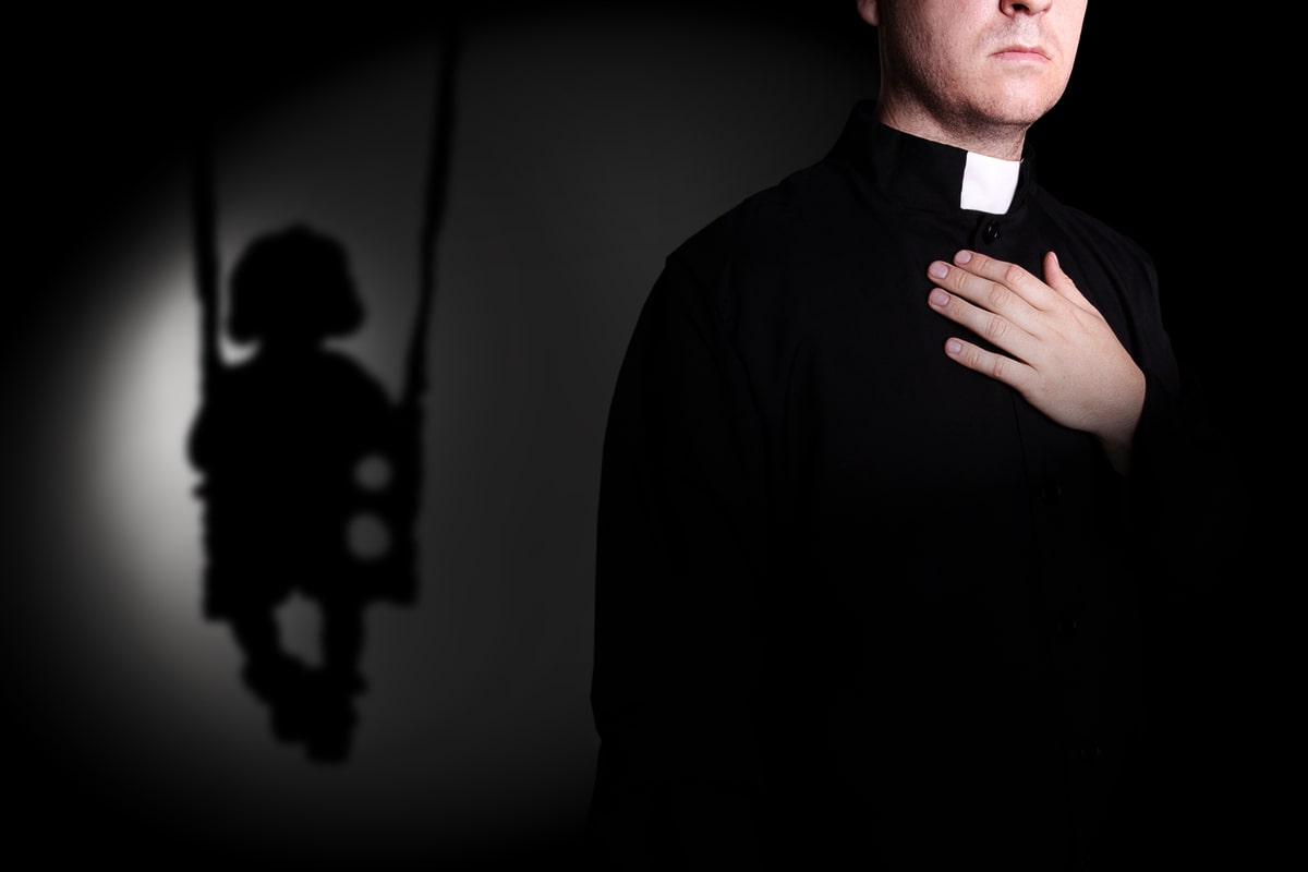 sacerdote con una bambina alle spalle