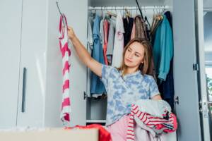 Una donna sistema i vestiti nell'armadio