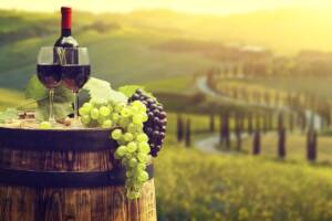 Paesaggio toscano con uva e vino in primo piano
