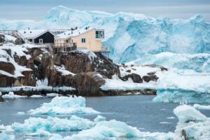 Paesaggio groenlandese: piccolo villaggio circondato da iceberg.