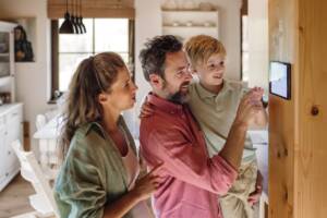 Famiglia che regola la temperatura dal termostato digitale.