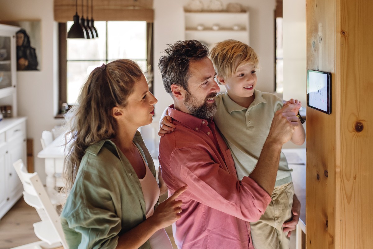 Famiglia che regola la temperatura dal termostato digitale.