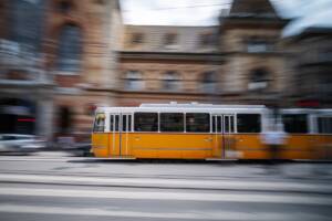 un tram giallo arancio in movimento per le vie della città