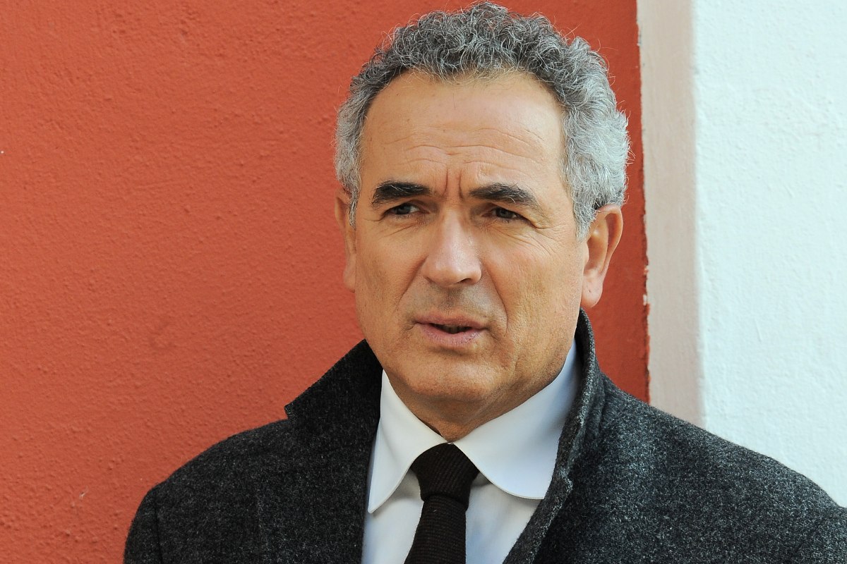 primo piano di Lamberto Sposini con una giacca scura e una cravatta