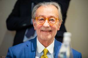 il giornalista Vittorio Feltri sorridente con una giacca e una cravatta