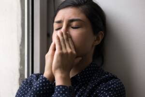 una ragazza con le mani sul volto per la disperazione