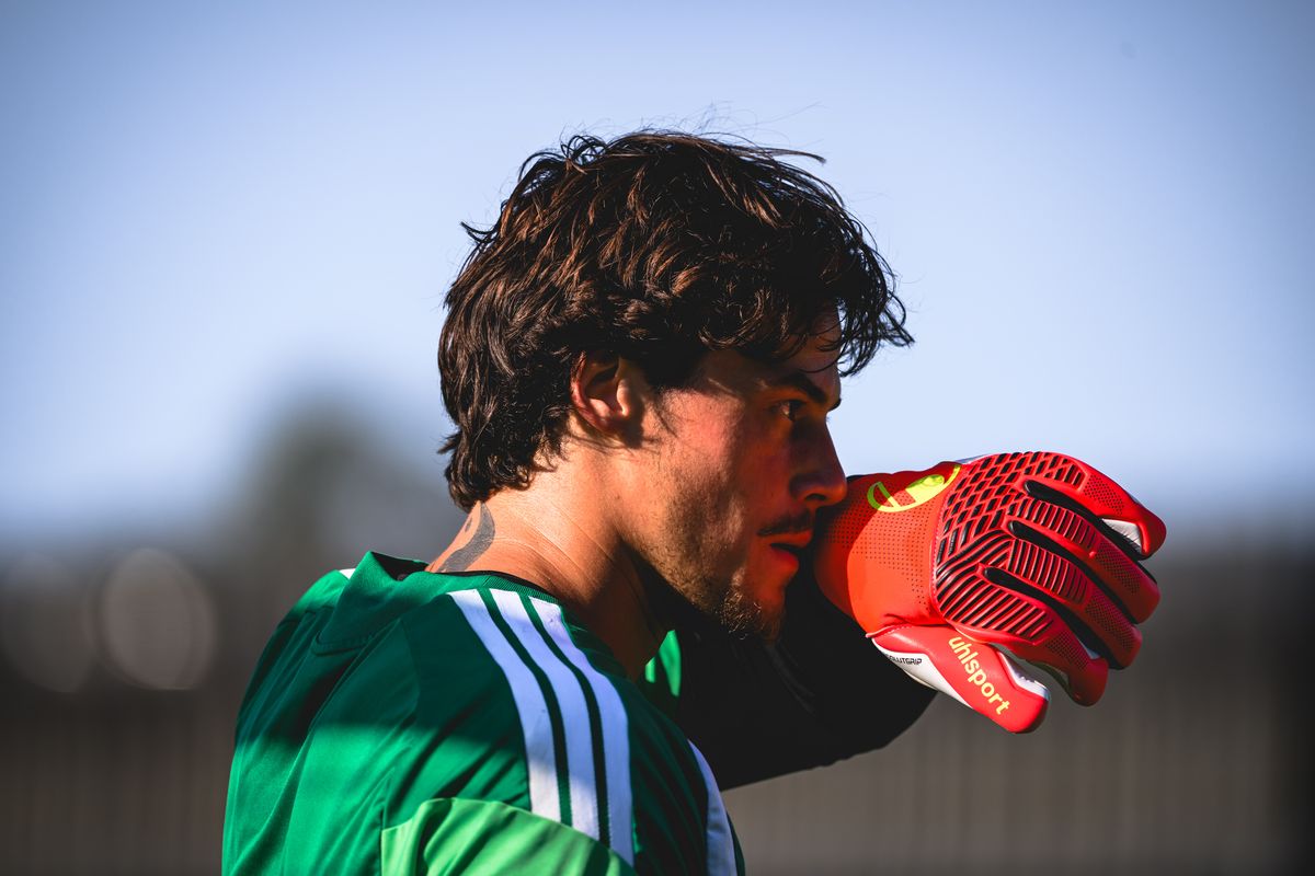 il portiere Mile Svilar in allenamento con la Roma si asciuga il sudore con il guantone