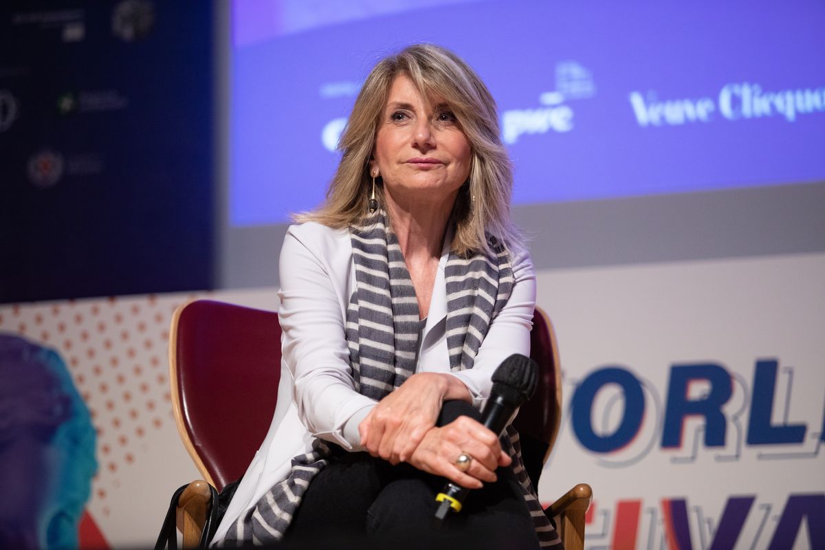 la giornalista Tiziana Ferrario parla ad un evento col microfono in mano
